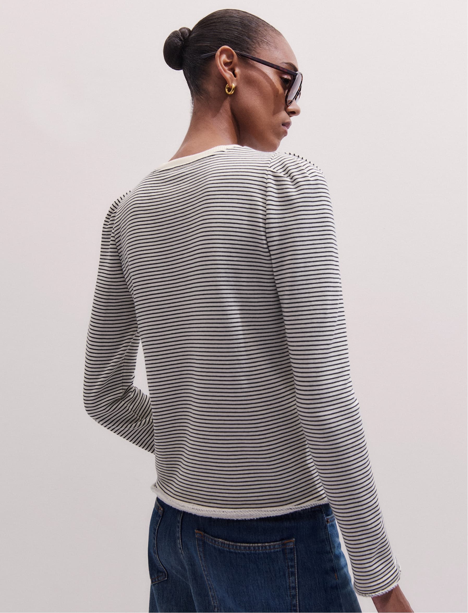 Woman facing away from the camera wearing a long-sleeved top.