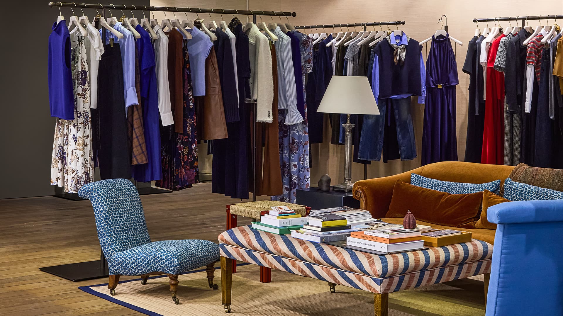Inside Genva store pop up with rails of clothes and stripe blue furniture on wooden floor
