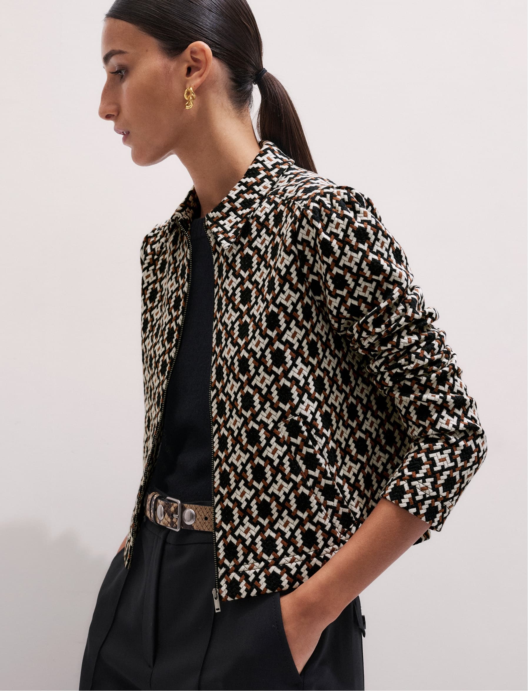 Woman wearing a patterned jacket and looking away from the camera.