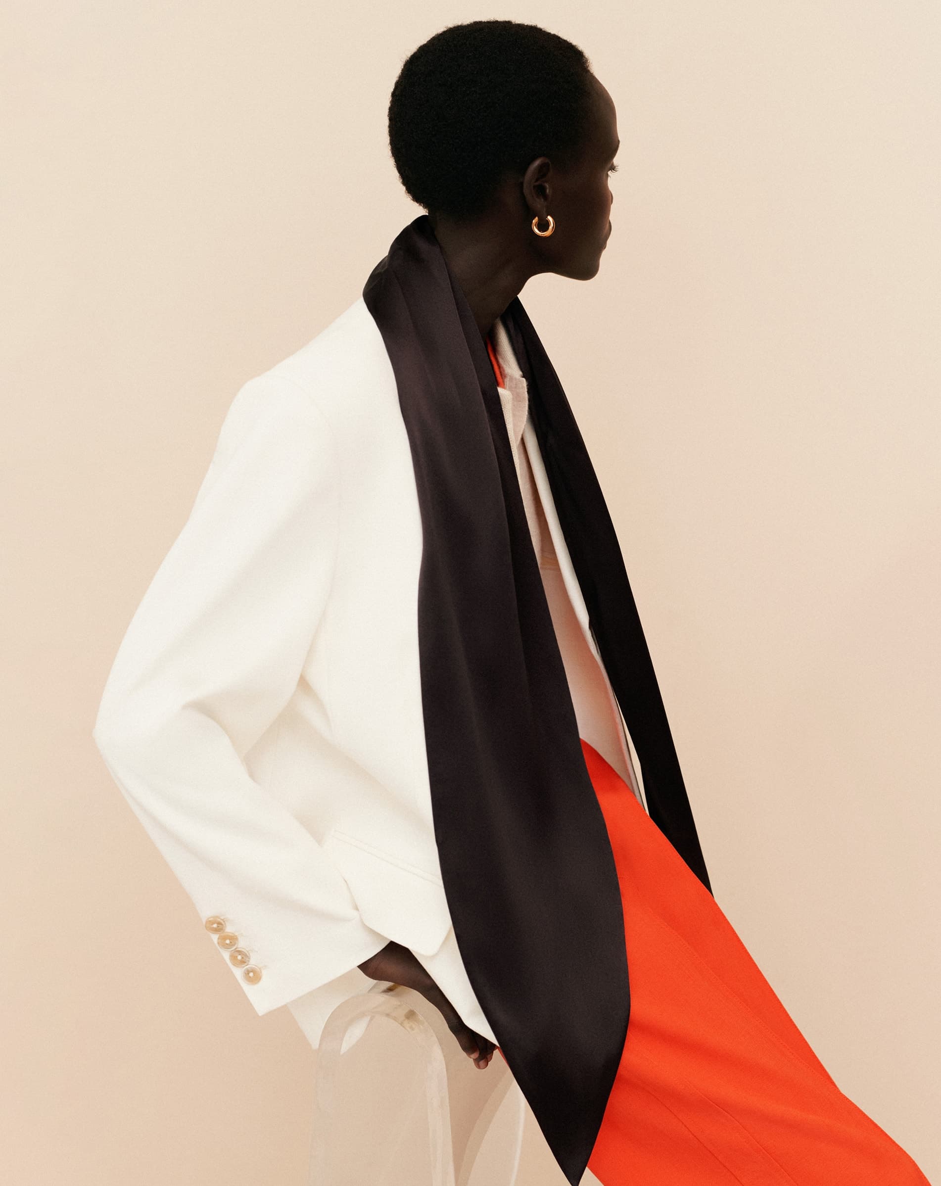 Side on shot of a woman wearing a white blazer.