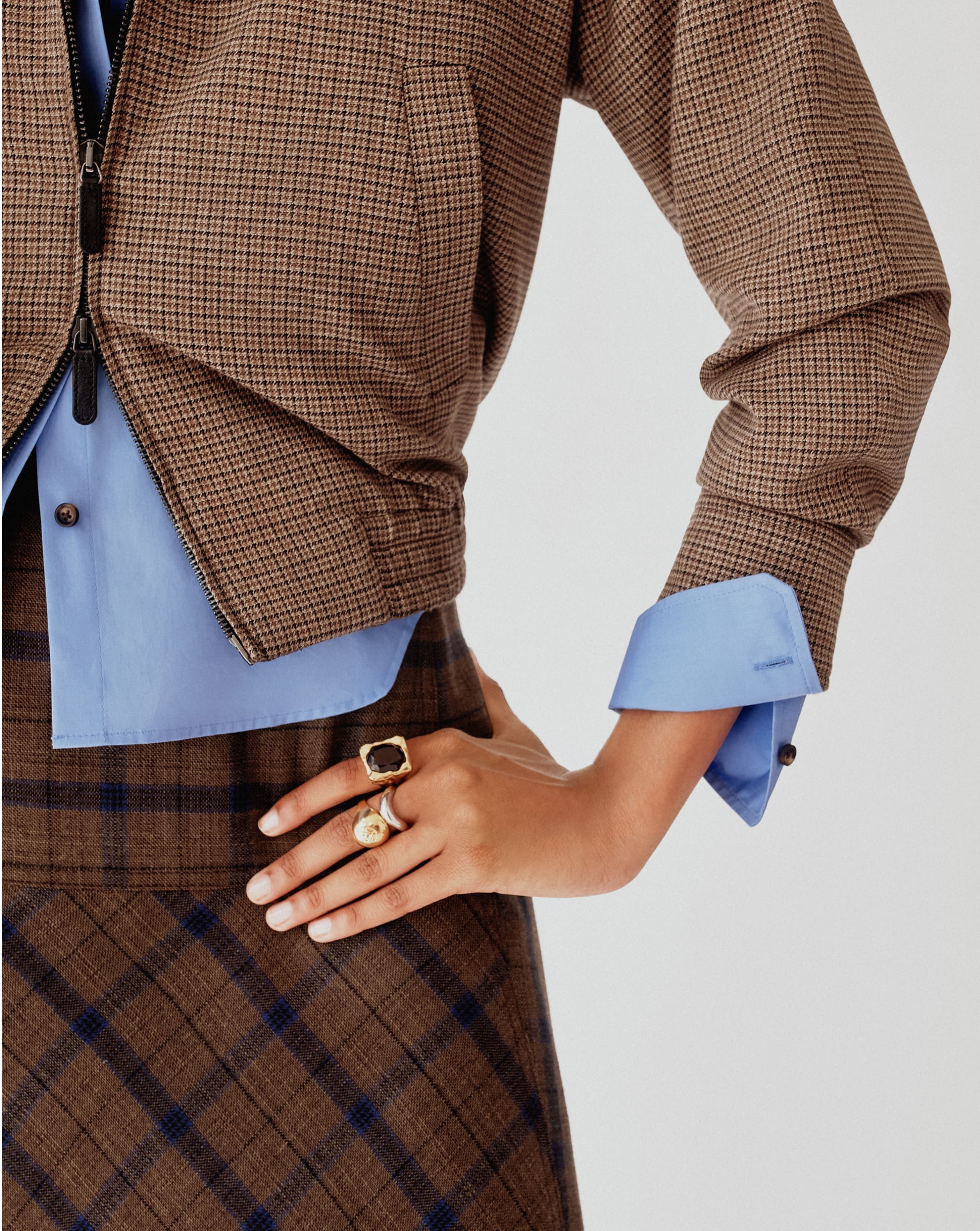 Close up of woman with hand on hip, wearing rings.