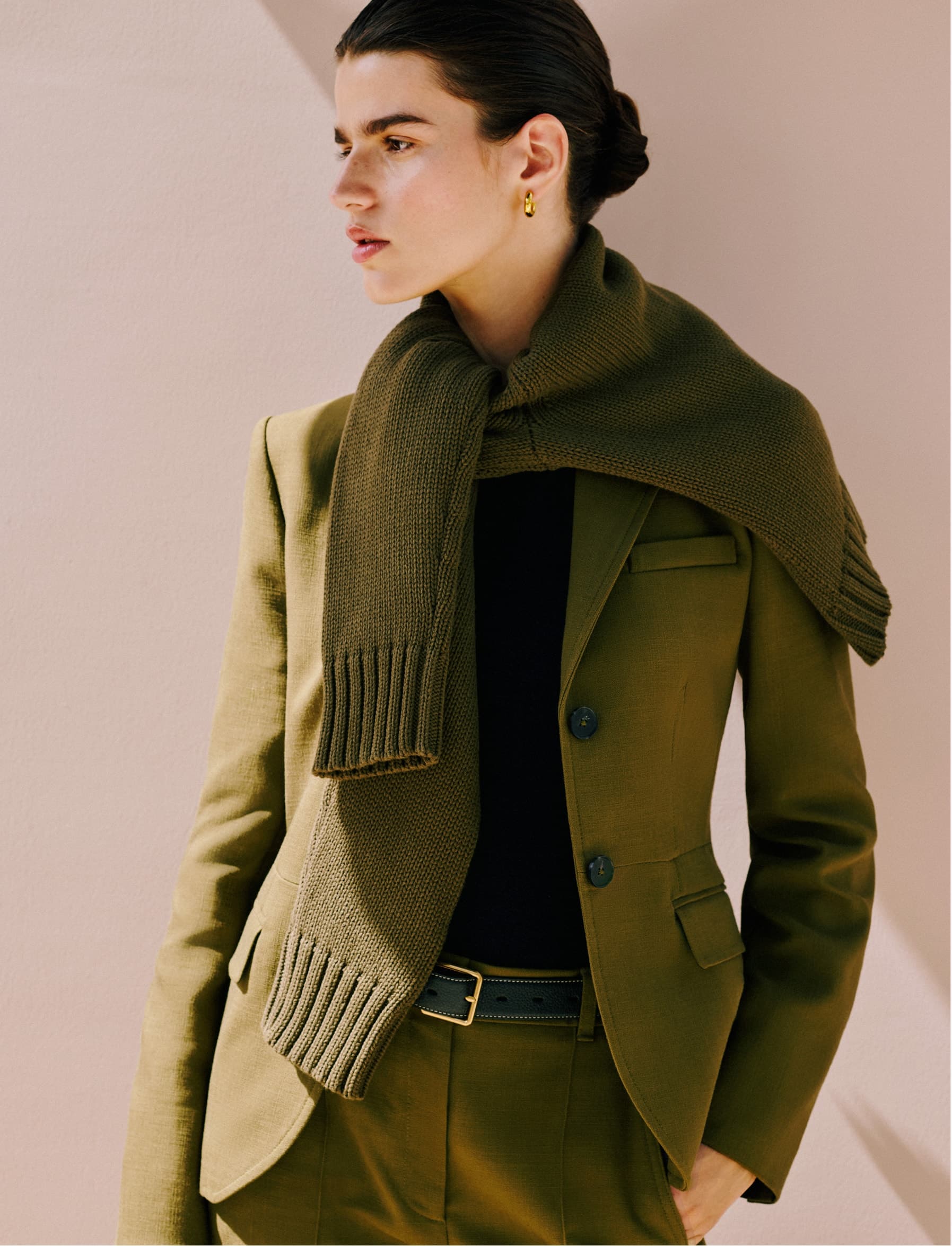 Model wearing a green blazer and green jumper.