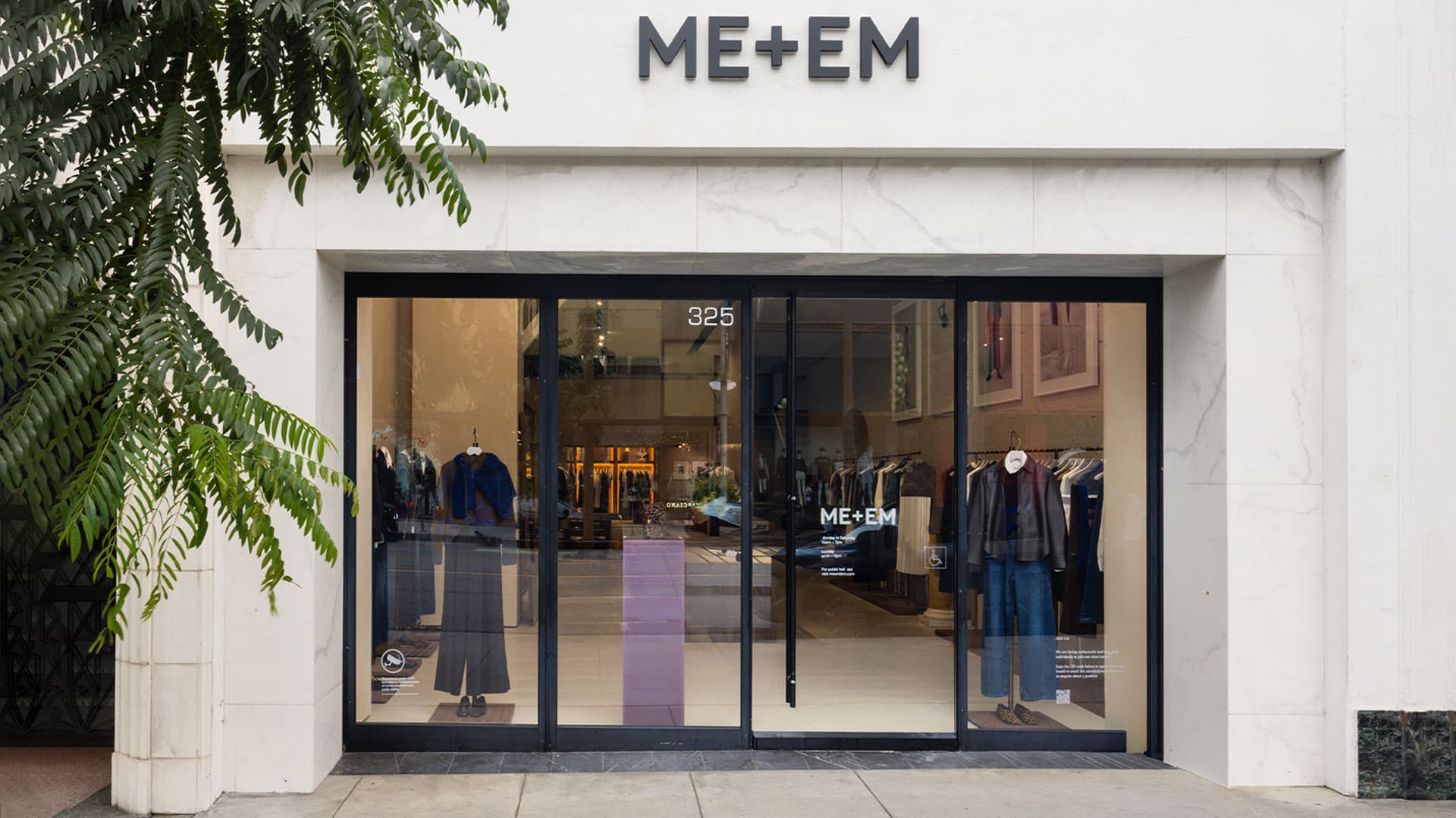 ME+EM LA store front with black trim windows with mannequins standing in windows